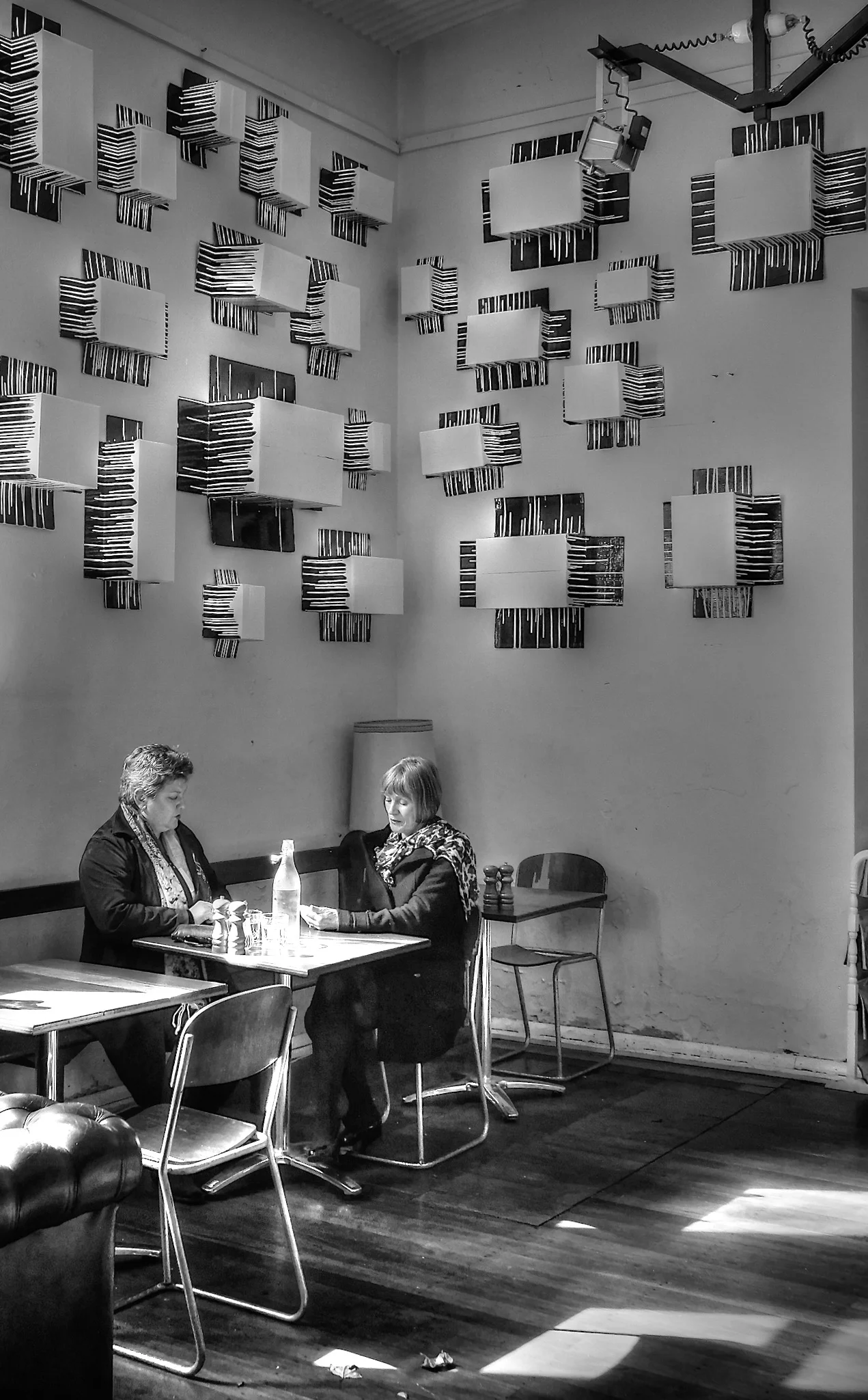 Peter Pickering snaps two ladies sitting at a table with drinks in a trendy cafe.